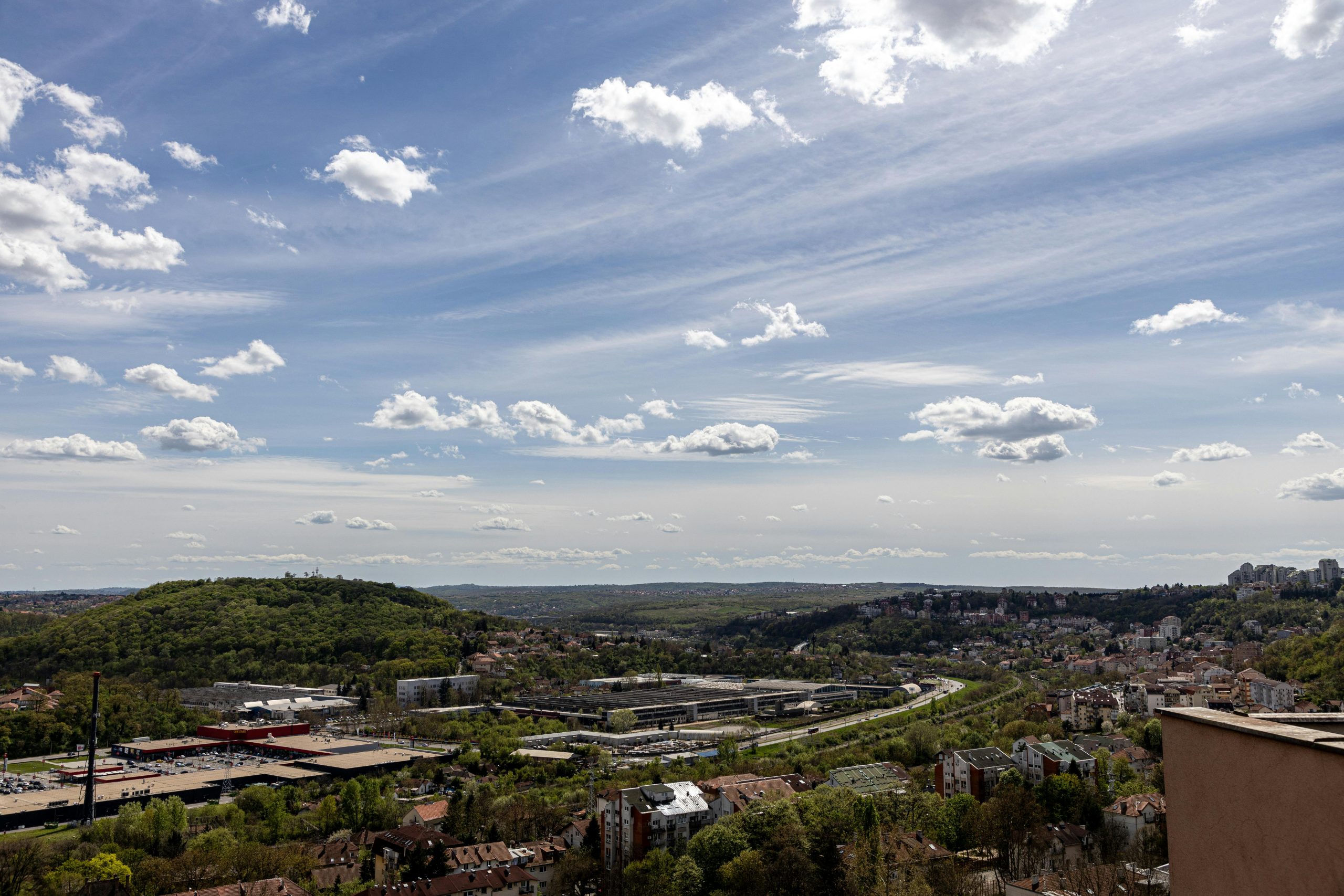 Overlooking a beautiful cityscape with hills under a vibrant summer sky.